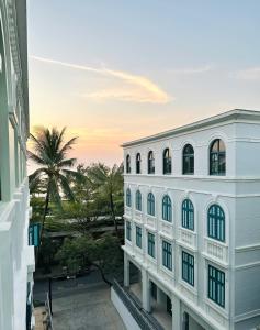 a white building with a palm tree in the background at My Marina Beach Hotel Phu Quoc in Phú Quốc