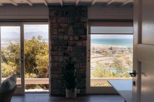 a room with two windows with a view of the ocean at Fabella Serenety Flat in Muizenberg