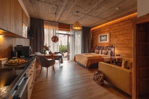 a hotel room with a bed and a kitchen and a bedroom at APARTAMENTY U HARREGO BOUTIQUE SPA masaże, sauna, tężnia solankowa , balkon , taras , klimatyzacja , parking in Kudowa-Zdrój