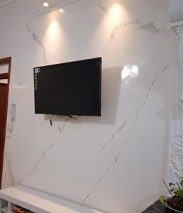 a flat screen tv hanging on a white wall at Martil Beach Apartment in Martil