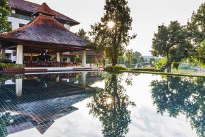 a pool in front of a building with a reflection in the water at RatiLanna Riverside Spa Resort in Chiang Mai +91 photos
