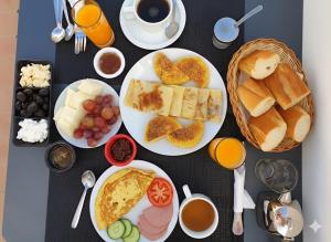 a table with plates of food and cups of coffee at Martil Beach Apartment in Martil