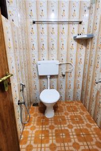 a bathroom with a toilet in a room with wallpaper at Greens Residency in Tripunittura +34 photos