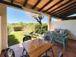 a patio with a wooden table and chairs on a patio at Olimar, vistas al mar y relax junto a la playa in L'Ampolla