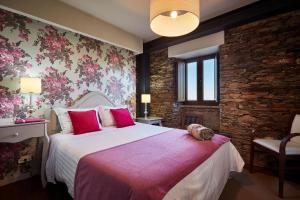 a bedroom with a large bed with pink pillows at Campus Natura in Arganil +42 photos