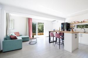 a kitchen and living room with a blue couch at The Olive Grove Cottage by Konnect - 2,5km from Ipsos in Ipsos