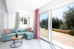 a living room with a couch and a large window at The Olive Grove Cottage by Konnect - 2,5km from Ipsos in Ipsos