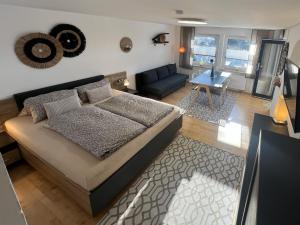a bedroom with a bed and a living room at H.Aus.Zeit Ferienwohnungen Stockbauer in Regen