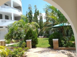 a courtyard with palm trees and a building at Kamsons in Mombasa
