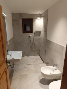 a bathroom with a sink and a toilet and a shower at Enzian, Obertörgglerhof in Brixen