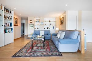 a living room with a blue couch and a rug at Itsas aurre Basquenjoy in Fuenterrabía