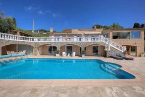 a large swimming pool in front of a house at Villa La Terre Des Lauriers in Vallauris