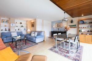 a living room with a blue couch and a table at Itsas aurre Basquenjoy in Fuenterrabía
