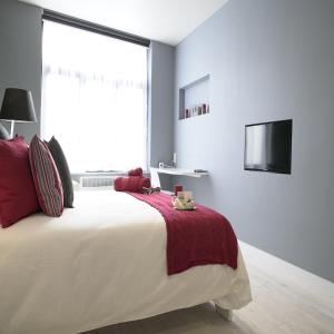a bedroom with a large bed and a tv at B&B Be In Brussels in Brussels