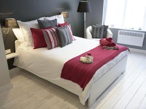 a bedroom with a large white bed with red and grey pillows at B&B Be In Brussels in Brussels