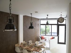 a dining room with a table and chairs and a clock at B&B Be In Brussels in Brussels