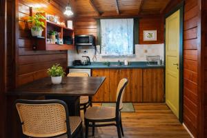 a kitchen with a table and chairs in a room at family cabin in Menaẖemya