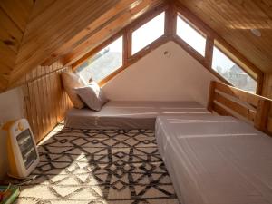a small room with two beds in a attic at Kuhama Private Mountain Chalet Naggar in Nagar