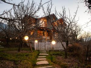a house with a white fence and lights at Kuhama Private Mountain Chalet Naggar in Nagar