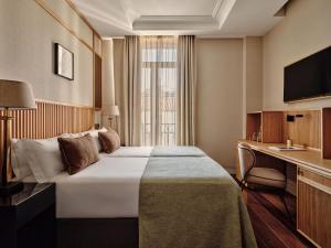 a hotel room with a bed and a desk at Hotel Único Madrid, Small Luxury Hotels in Madrid