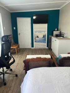 a bedroom with two beds and a desk and a kitchen at Grace from Above in Malmesbury