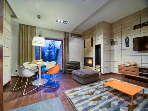 コシチェリスコにあるVisitZakopane - Adriatic Apartmentのリビングルーム(テーブル、椅子、暖炉付)