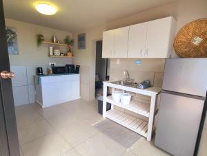a kitchen with white cabinets and a sink and a refrigerator at VitaminSea in Mossel Bay
