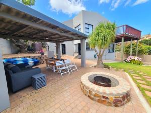 a patio with a couch and a fire pit at VitaminSea in Mossel Bay