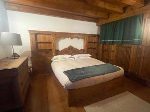 a bedroom with a bed and a dresser in a room at Chalet Alba in Cortina dʼAmpezzo