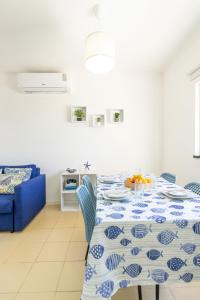 a table with a blue and white table cloth on it at Picos House in Lajes do Pico