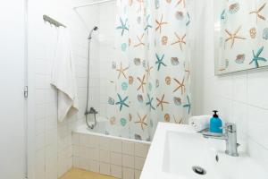 a bathroom with a sink and a shower curtain at Picos House in Lajes do Pico +65 photos