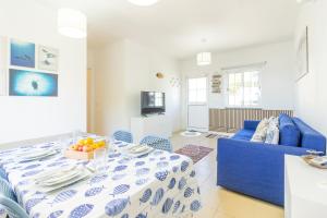 a living room with a table and a blue couch at Picos House in Lajes do Pico
