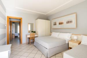 a hotel room with two beds and a desk at Hotel Sport & Residenza in Cesenatico +33 photos