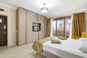 a bedroom with a large bed and a tv at REYNA APART HOTEL in Constanţa