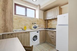 a kitchen with a washing machine and a refrigerator at REYNA APART HOTEL in Constanţa