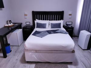 a bedroom with a large white bed with two night stands at Hotel Redcliff in Redcliff