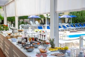 a buffet of food on a table next to a pool at Hotel Sport & Residenza in Cesenatico