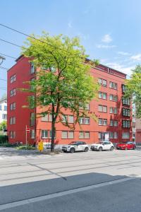 a red building with cars parked in front of it at CITY STAY - Kieselgasse in Zurich