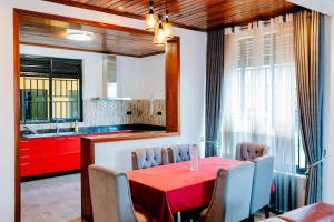 a dining room with a red table and chairs at Villa d'exception Rebero in Kigali