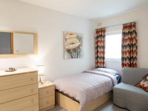 a bedroom with a bed and a dresser and a window at Birgu Seafront 3 Bedroom Apartment in Vittoriosa