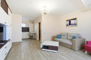 a living room with a couch and a tv at REYNA APART HOTEL in Constanţa