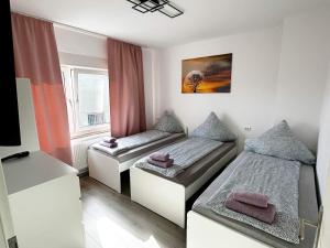 a room with two beds and a tv in it at Gemütliche Apartments in Herten in Herten