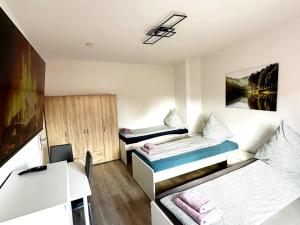 a small room with two beds and a desk at Gemütliche Apartments in Herten in Herten
