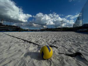 a yellow volley ball sitting on the sand on a soccer field at Arena Bitz in Pato Branco +2 photos