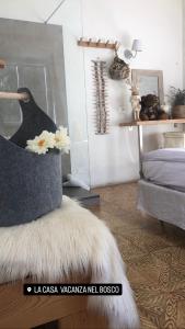 a living room with a chair with a white fur at Agriturismo La Casa Nel Bosco in Boveglio