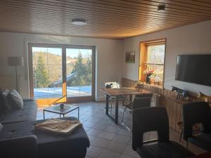 a living room with a couch and a table at Schöner Ausblick in Bad Kohlgrub