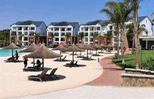 a group of chairs and umbrellas on a beach at The Blyde Crystal lagoon Pretoria in Pretoria
