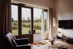 a living room with a sliding glass door to a patio at Huize Henk in Emst