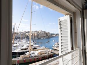 a balcony with a view of a marina with boats at Birgu Seafront 3 Bedroom Apartment in Vittoriosa