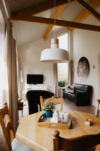 a living room with a wooden table and a dining room at Huize Henk in Emst
